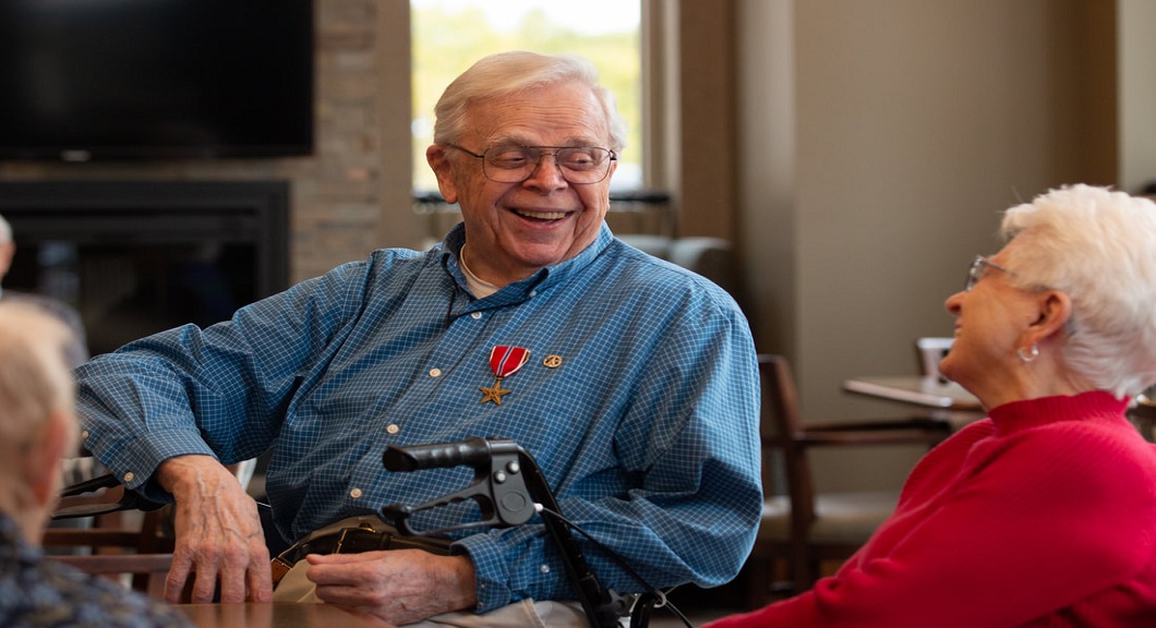caregiver and elder woman smiling to each other